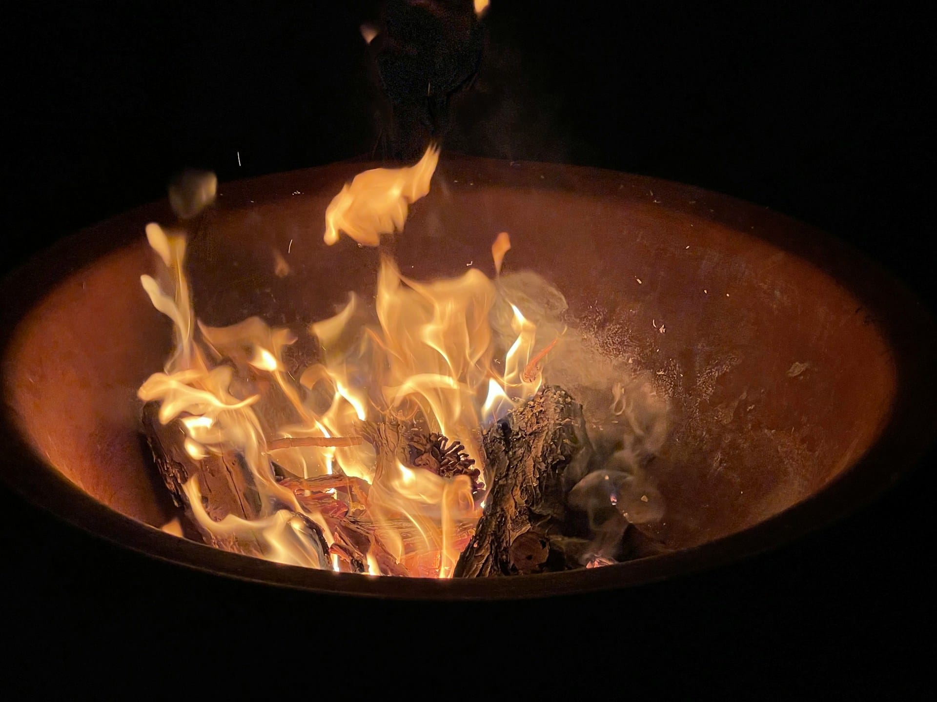 Feuerschale an Silvester im Ebengut: Gäste genießen Glühwein in ruhiger, gemütlicher Atmosphäre – ohne Feuerwerk, im Einklang mit Natur und Tieren.